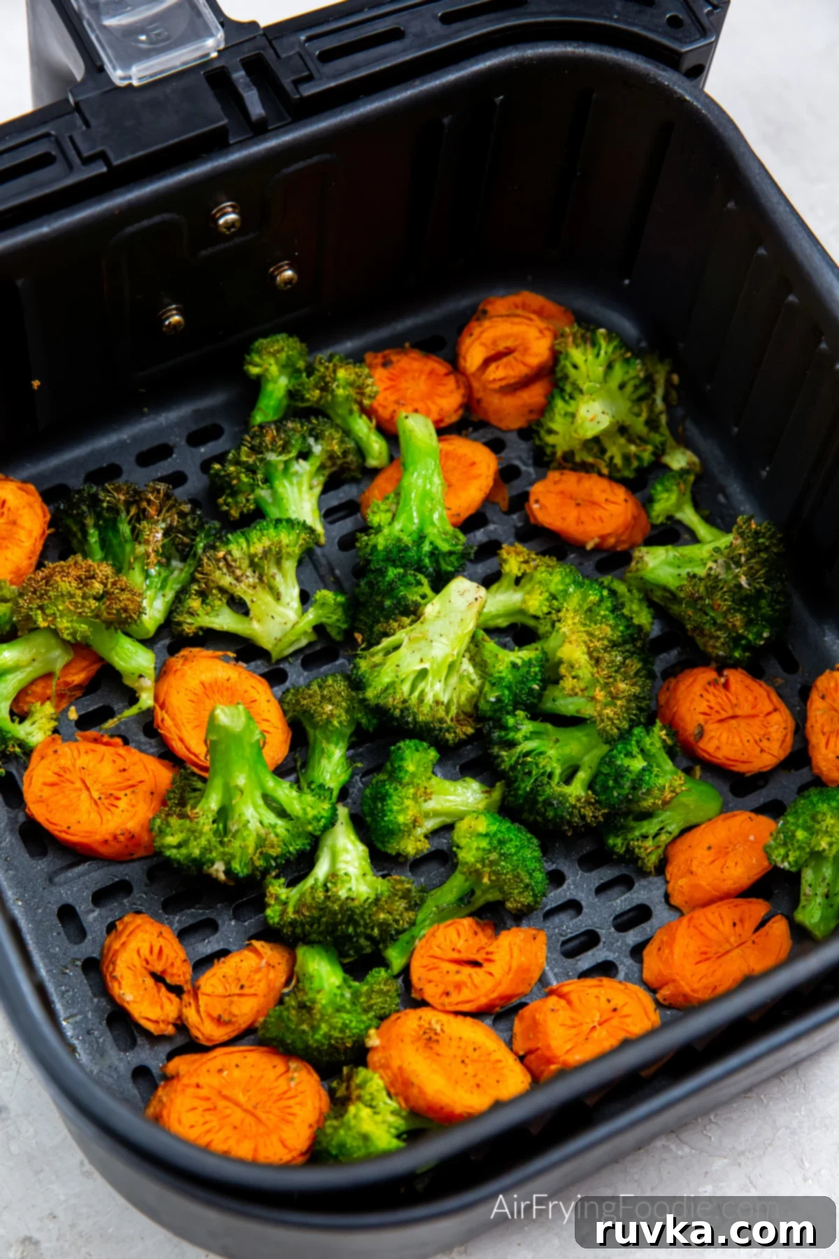 Crispy Air Fryer Broccoli and Carrots 2 Broccoli and carrots in the basket of the air fryer.