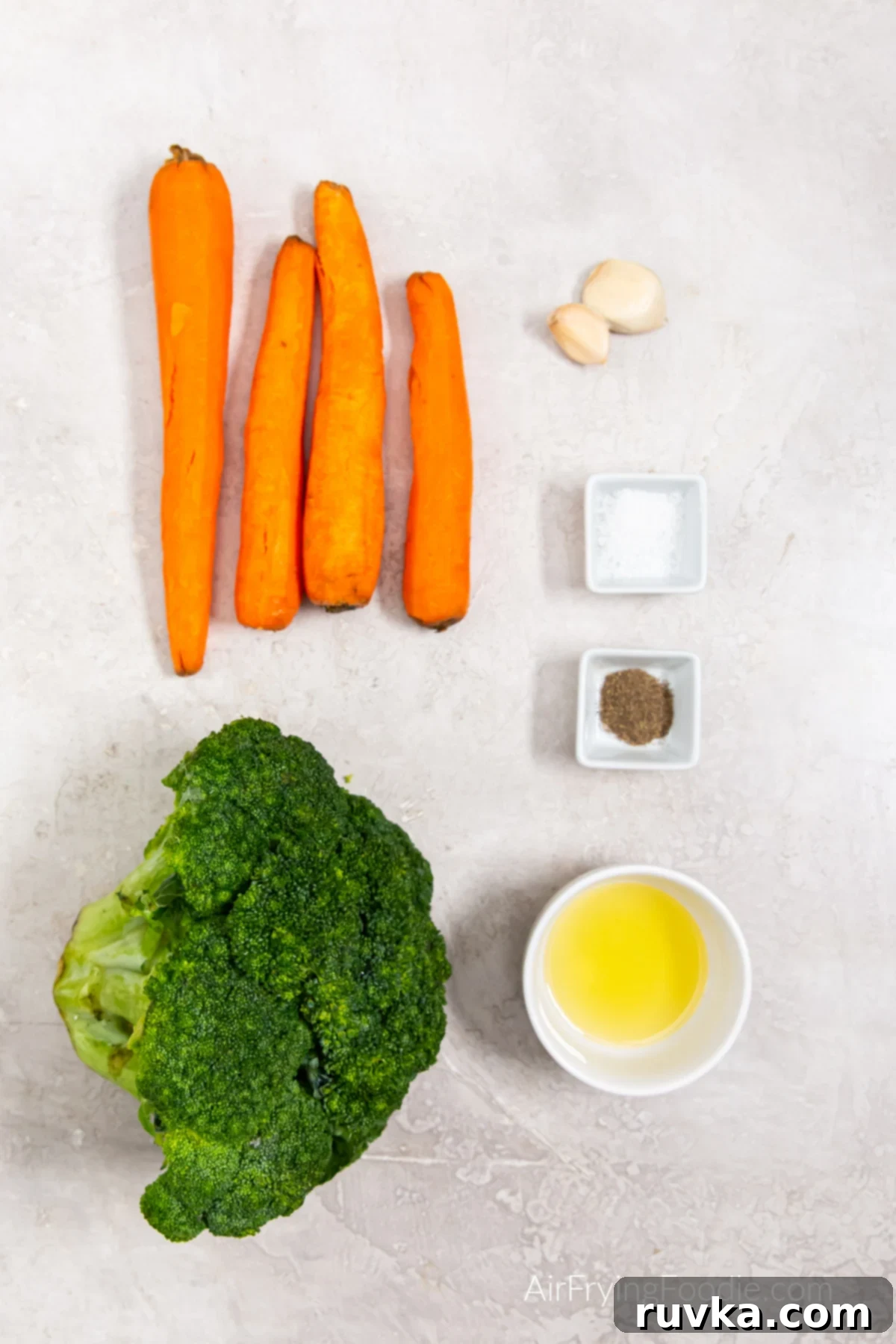 Crispy Air Fryer Broccoli and Carrots 3 Broccoli, carrots, garlic, oil, and seasonings on a table.