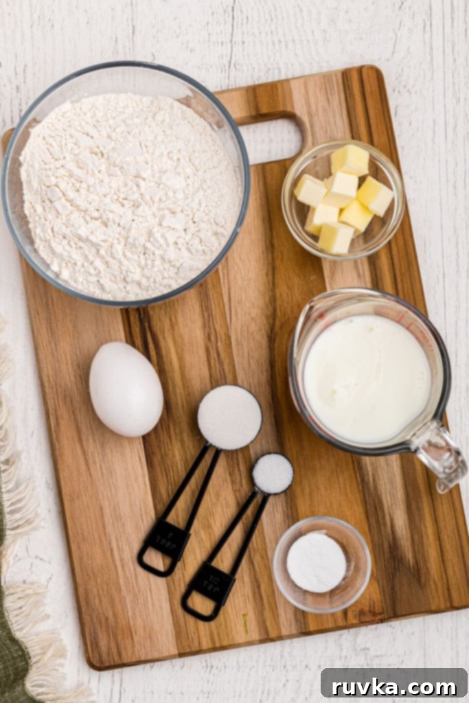 Easy Air Fryer Irish Soda Bread 3 Ingredients needed to make Irish Soda Bread measured in clear glass bowls on a wooden cutting board.