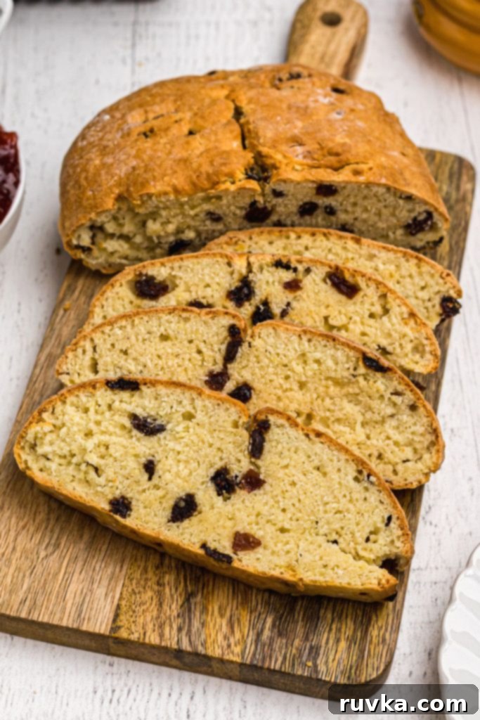 Easy Air Fryer Irish Soda Bread 9 Golden soft bread sliced on a wooden cutting board.