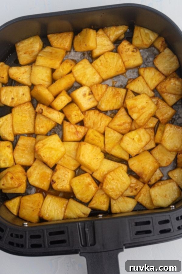 Air-Fried Caramelized Pineapple 5 Cooked golden juicy pineapple in an air fryer basket.
