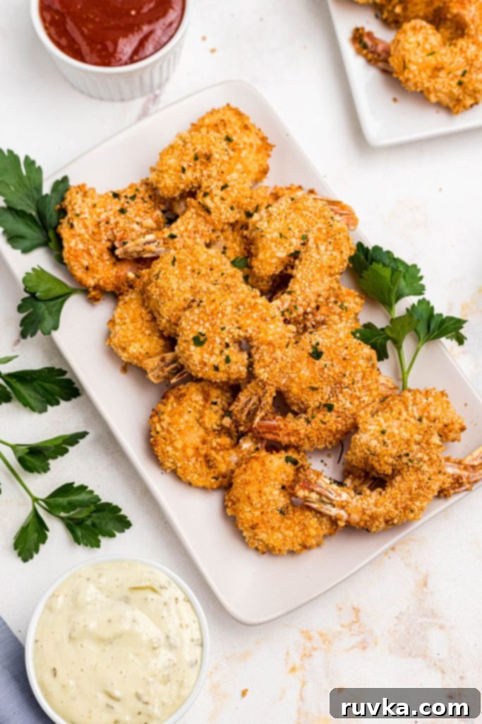 Crispy Air Fryer Breaded Shrimp 2 Golden breaded shrimp on a white square plate