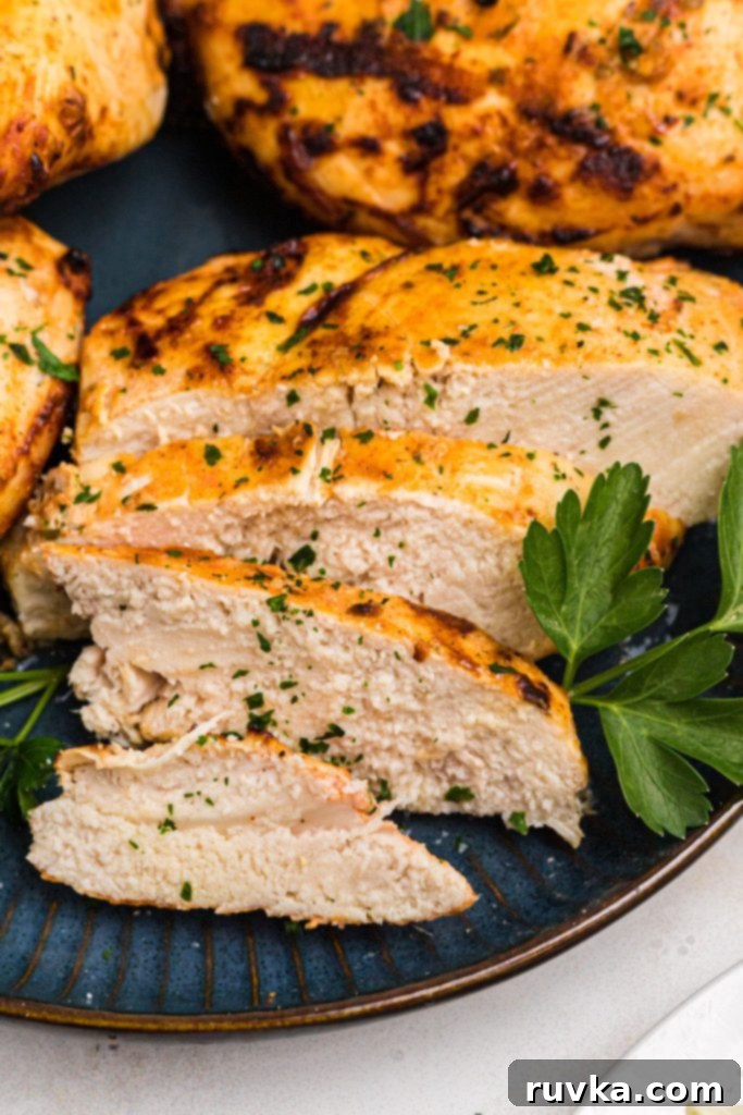 Tender Air Fryer Yogurt Chicken 8 Golden juicy chicken sliced on a blue plate with parsley garnish.