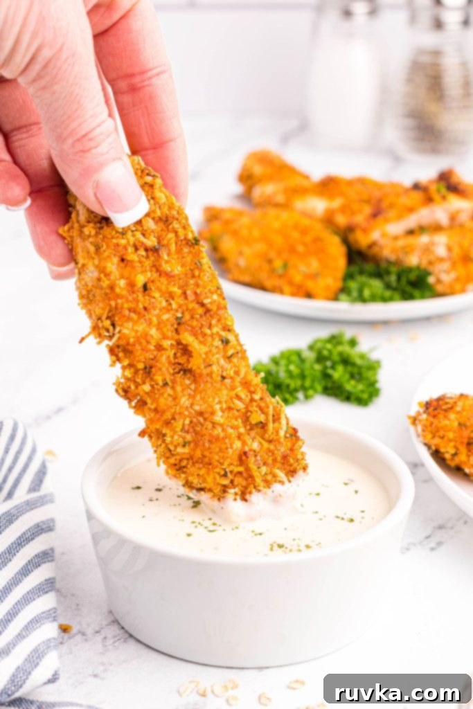 Crispy Golden Oat Air Fryer Chicken 9 Oatmeal crusted chicken being dipped into ranch
