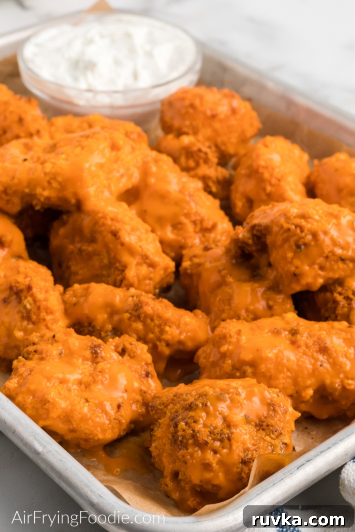 Crispy Air Fryer Boneless Wings 2 Boneless wings made in the air fryer, covered in sauce and served on a tray.