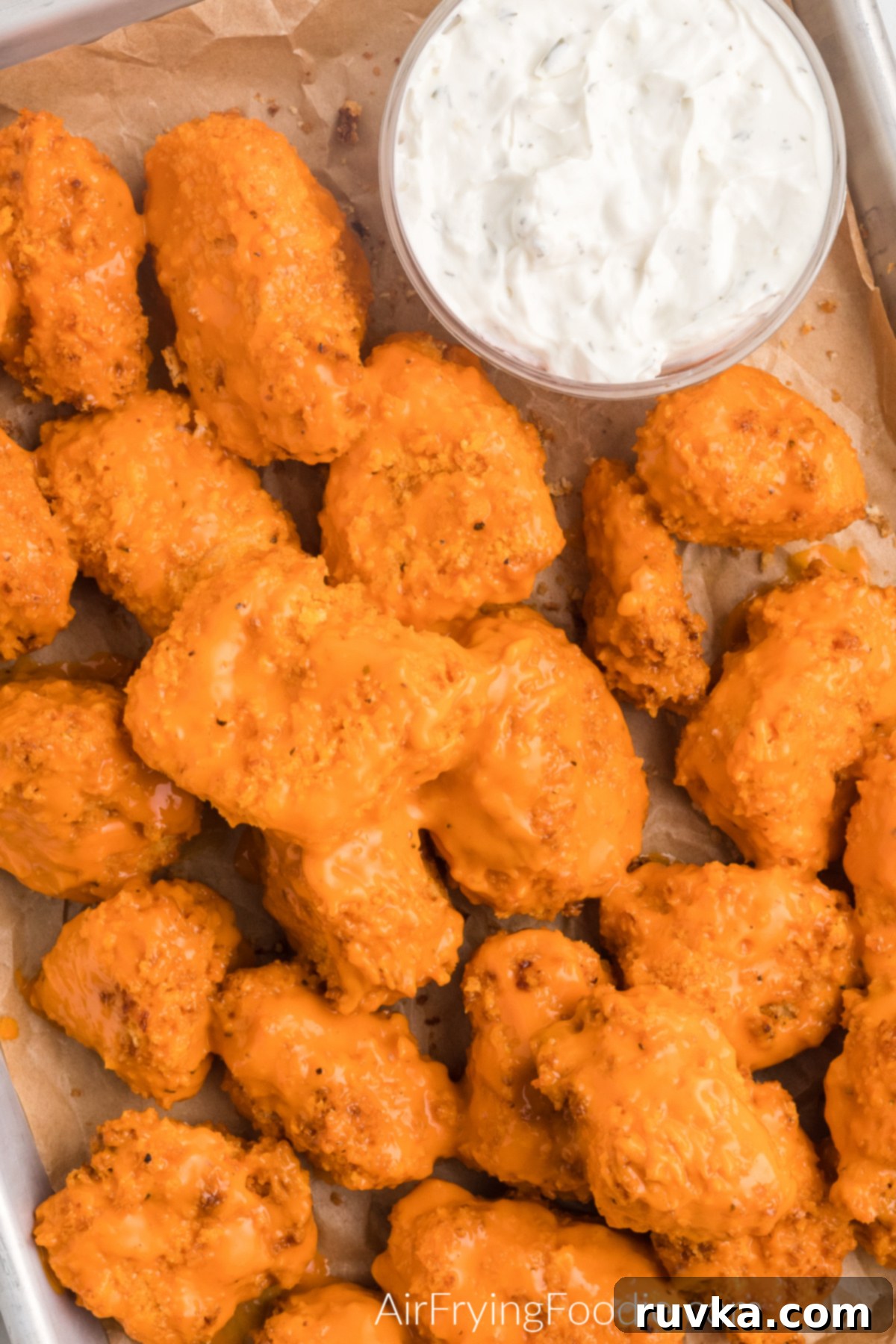 Crispy Air Fryer Boneless Wings 12 Close up overhead photo of boneless chicken wings made in the air fryer and topped with sauce. Ready to serve.