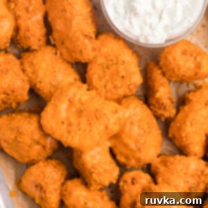 Crispy Air Fryer Boneless Wings 13 Boneless wings made in the air fryer, topped with sauce, and served with dipping sauce on a tray.