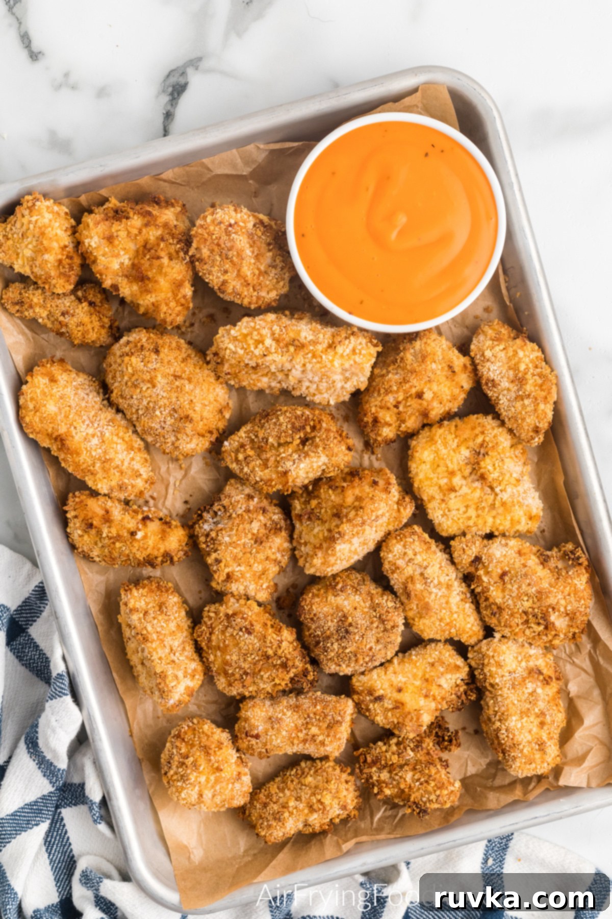 Crispy Air Fryer Boneless Wings 9 Air fryer boneless wings served on a tray with a side of buffalo dipping sauce.