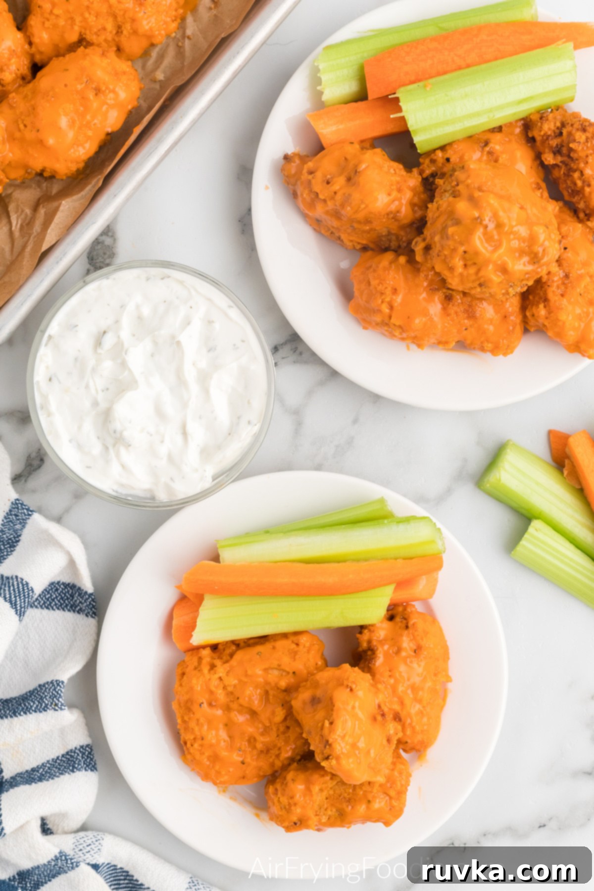 Crispy Air Fryer Boneless Wings 10 Wings topped with sauce and served on a plate with celery and carrots.