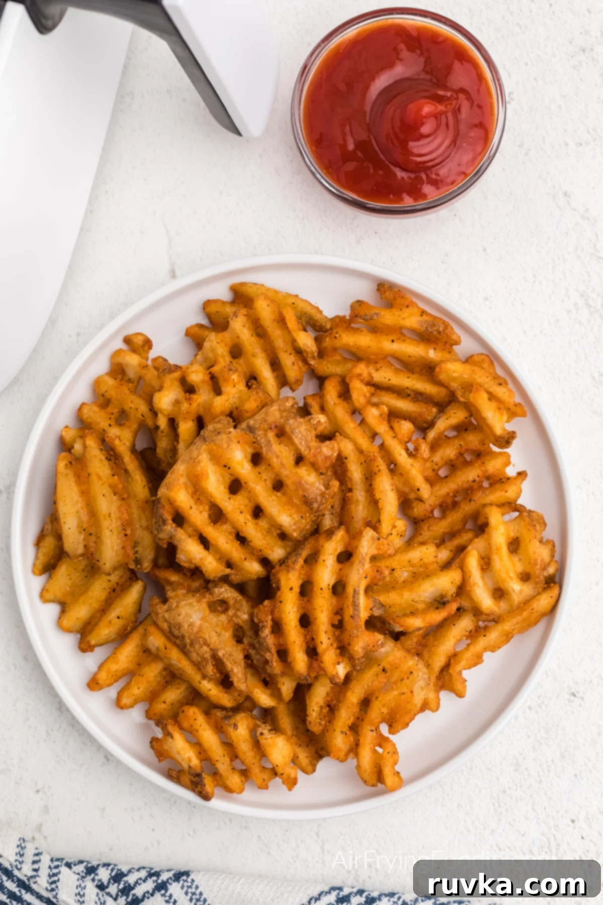 Crispy Air Fryer Waffle Fries 6 Air fried waffle cut fries on a white plate, ready to eat.