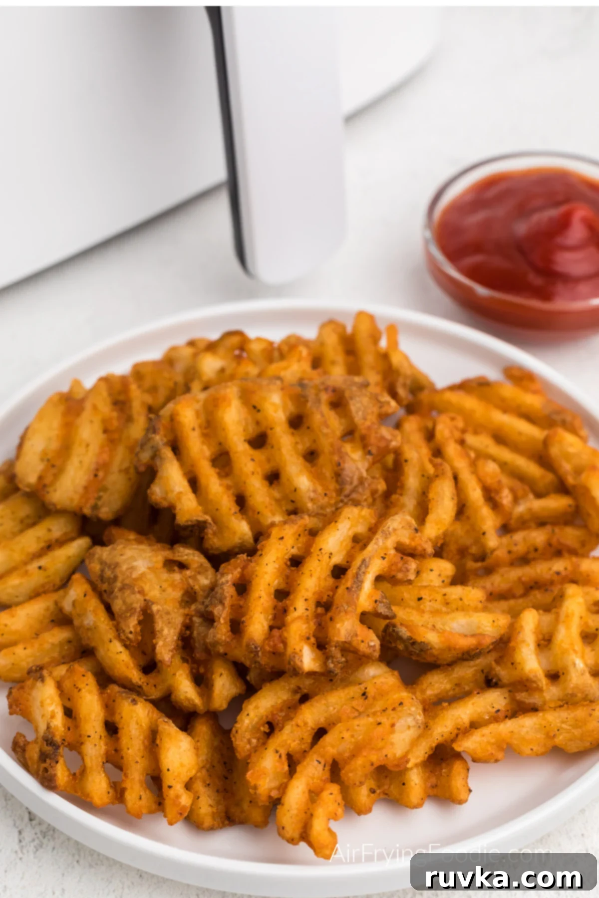Crispy Air Fryer Waffle Fries 7 Seasoned air fryer waffle fried on a white plate, ready to eat.