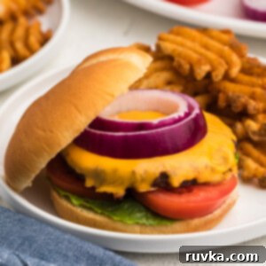 Perfect Air Fryer Frozen Burgers 9 Air fryer frozen burger made with cheese and topped with onion, tomato, and lettuce.