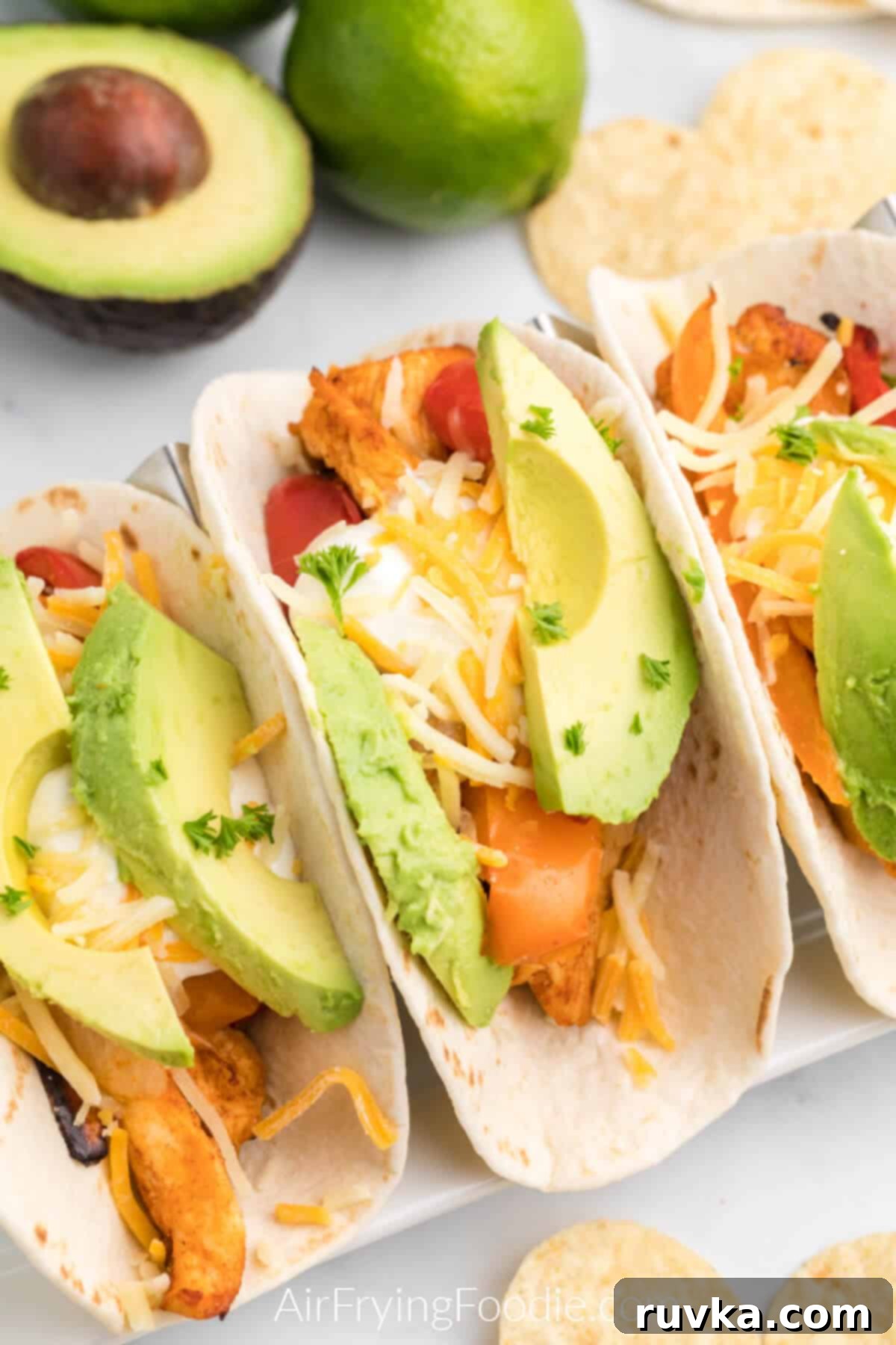 Easy Air Fryer Chicken Fajitas 38 chicken fajitas topped with avocado and cheese, ready to serve.