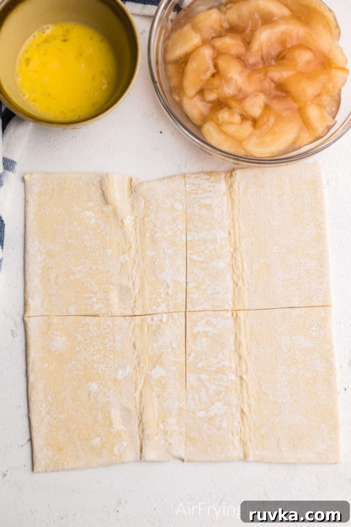 Crispy Air Fryer Apple Turnovers 4 Puff pastry sheets cut into 4 squares, egg in a bowl, apple filling in a bowl.