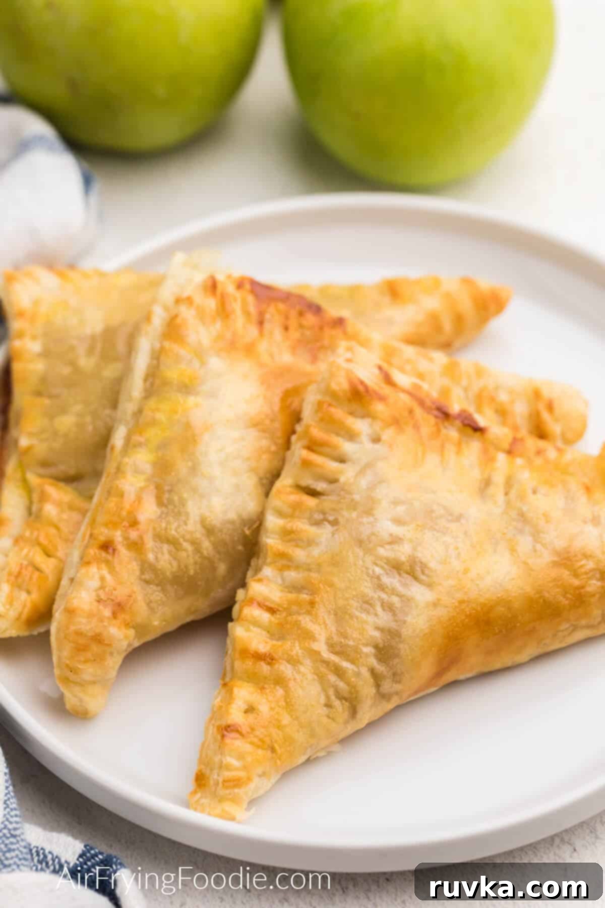 Crispy Air Fryer Apple Turnovers 10 Air fried apple turnovers served on a white plate with a fork, ready to be enjoyed.