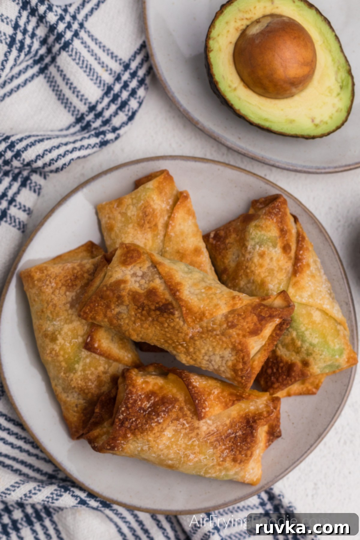 Crispy Air Fryer Avocado Bacon Egg Rolls 11 A vibrant plate stacked high with golden-brown Air Fried Avocado Bacon Egg Rolls, ready to be enjoyed.