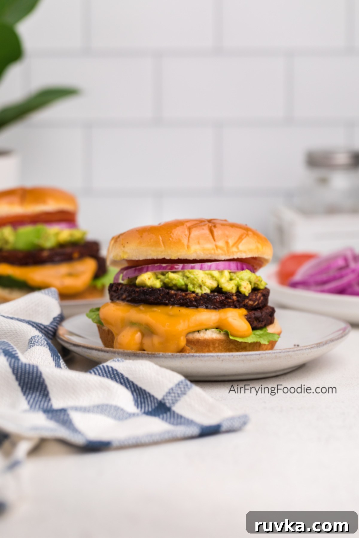 Crispy Air Fryer Black Bean Burger 7 Black bean burgers made in the air fryer and topped with seasoned mashed avocado, onion, tomato, and sauce.