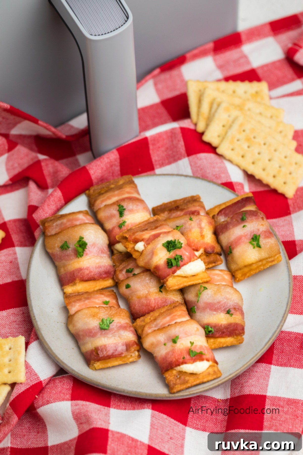 Air Fryer Bacon Cream Cheese Cracker Bites 58 Air fried bacon wrapped cream cheese crackers on a plate ready to serve.