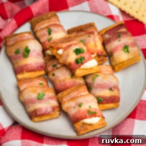 Air Fryer Bacon Cream Cheese Cracker Bites 12 Bacon wrapped cream cheese crackers on a plate, ready to serve.