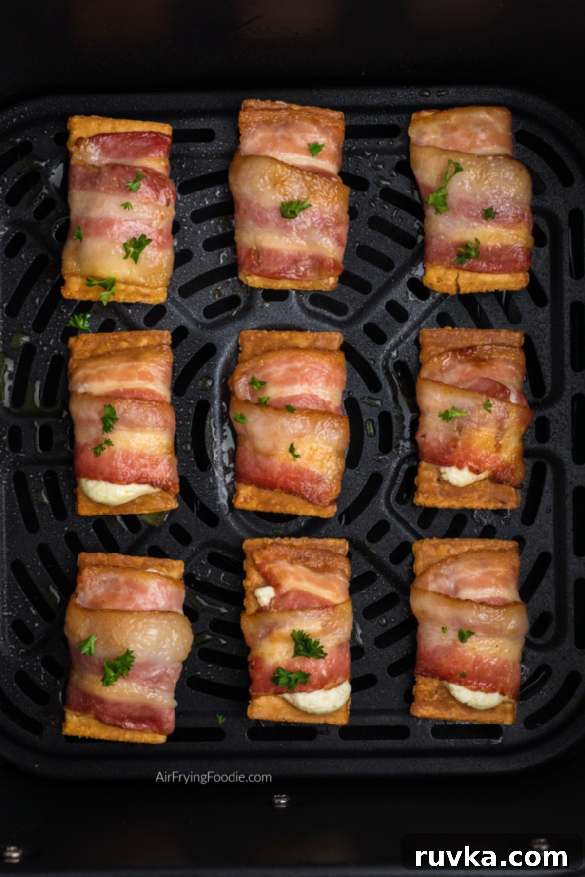 Air Fryer Bacon Cream Cheese Cracker Bites 10 Close up photo of air fried bacon wrapped cream cheese crackers in the basket of the air fryer.