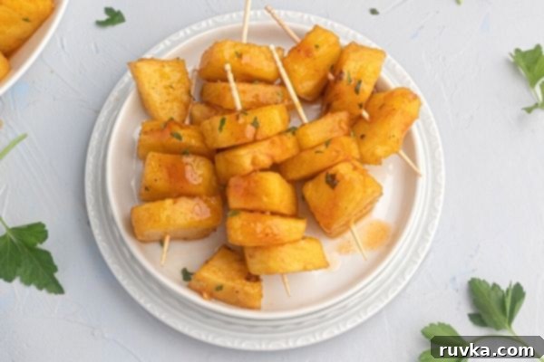 Air Fried Honey BBQ Pineapple 2 Juicy glazed pineapple served on a white plate, showcasing the golden-brown caramelized edges.