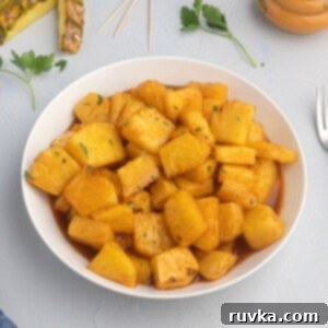 Air Fried Honey BBQ Pineapple 7 Juicy pineapple glazed with honey and bbq sauce, served in a white bowl, glistening with flavor.