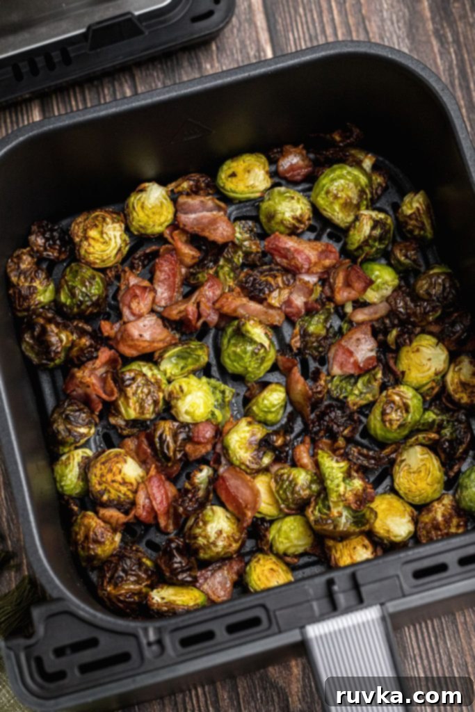 Crispy Air Fryer Brussels Sprouts and Bacon 9 Green crispy juicy brussels sprouts with crispy bacon pieces in the air fryer basket.