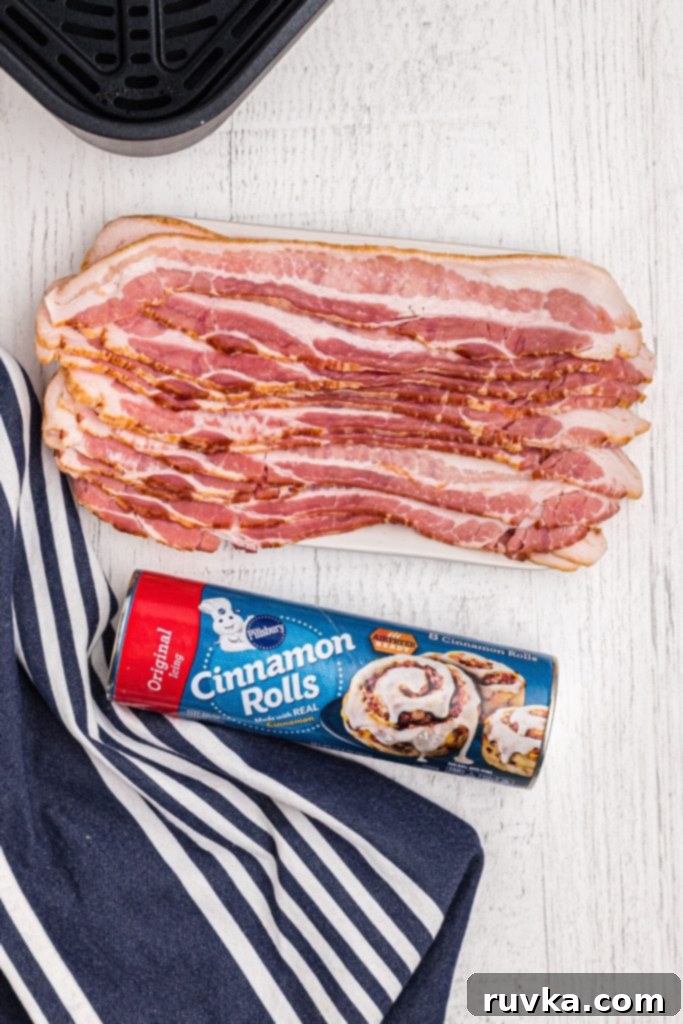 Air Fried Bacon Cinnamon Delights 3 Uncooked bacon slices and a can of cinnamon rolls on a white wooden table.