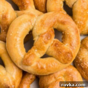 Perfectly Soft Air Fryer Pretzels 11 Golden soft pretzels on a white plate
