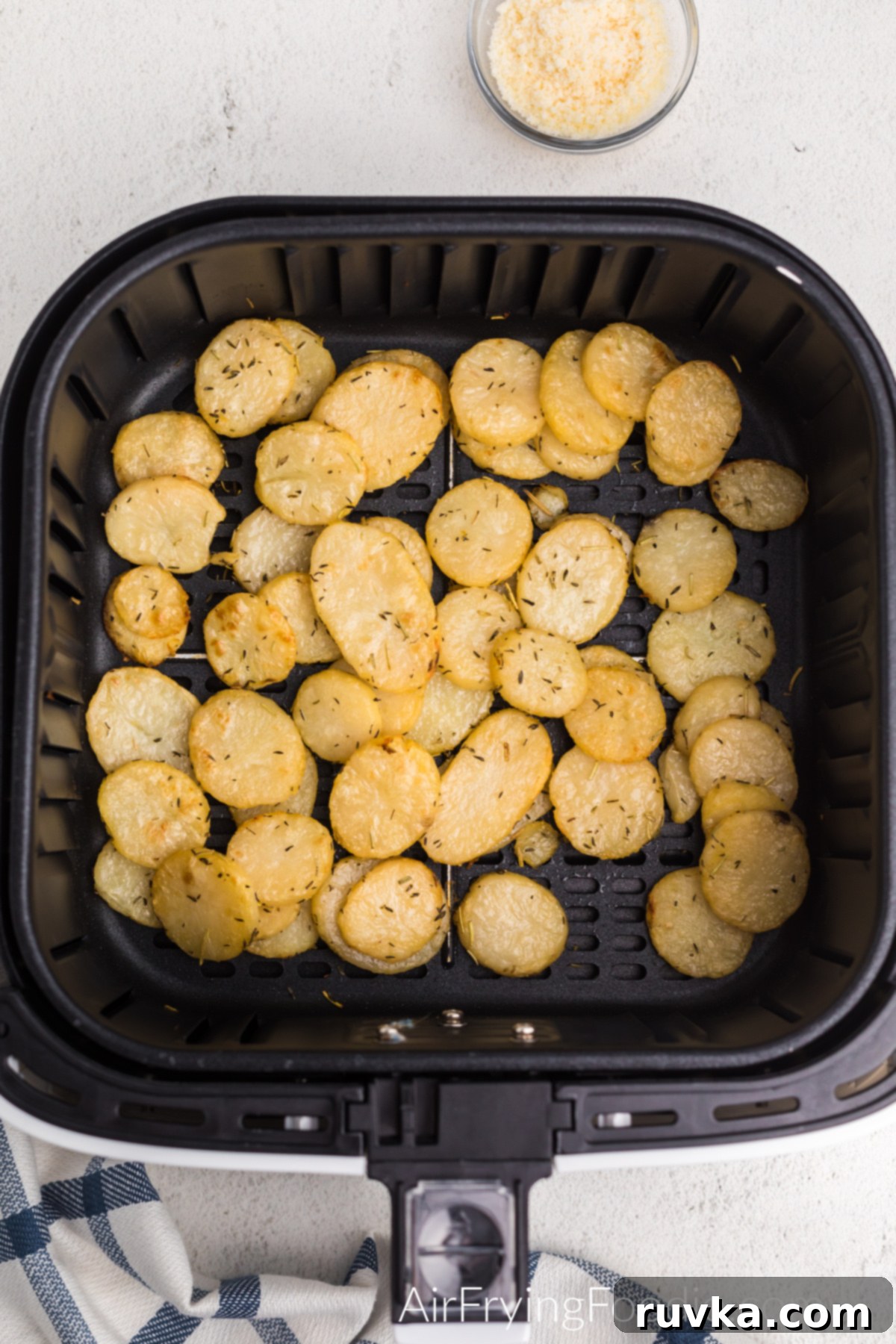 Air fried sliced potatoes in the basket of the air fryer, looking golden brown and perfectly cooked.
