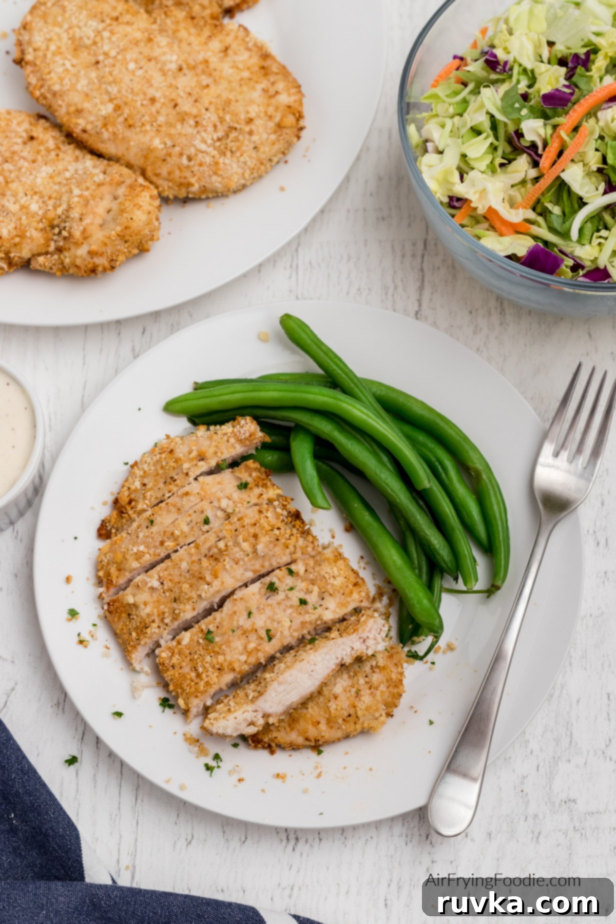 Crispy Air-Fried Chicken Breast 2 Plate with green beans and sliced fried chicken breast made in the air fryer.