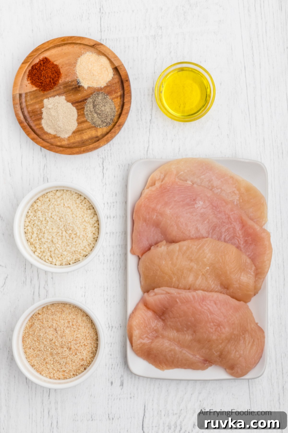 Crispy Air-Fried Chicken Breast 3 Chicken breasts, breadcrumbs, panko, seasonings, and olive oil on a table.