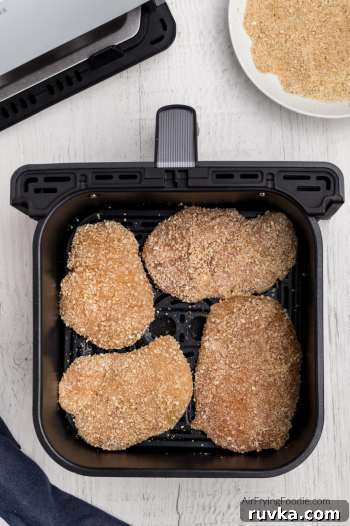 Crispy Air-Fried Chicken Breast 6 Breaded seasoned chicken breast in basket of air fryer.