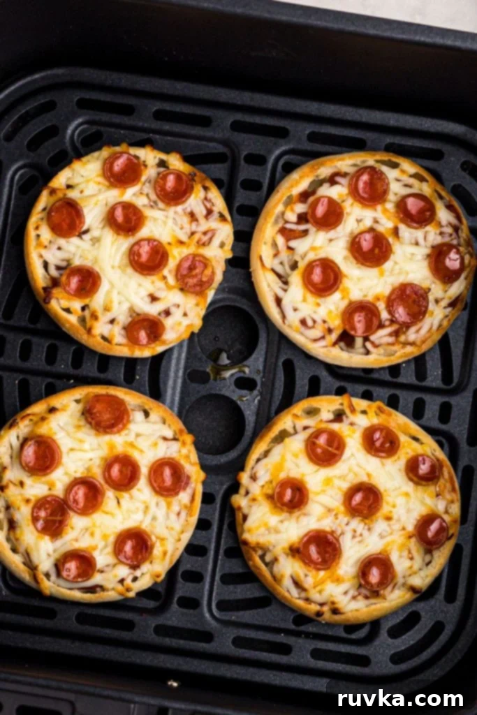 Easy Air Fryer English Muffin Pizzas 7 Perfectly golden and crispy English Muffin Pizzas with melted cheese, fresh out of the air fryer basket.