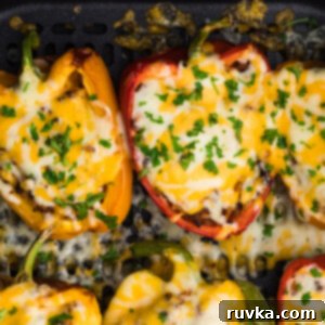 Air Frying Made Simple 13 Stuffed bell peppers in the basket of the air fryer, cooked to perfection.