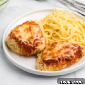 Air Frying Made Simple 25 Air Fryer chicken parmesan on a white plate with spaghetti noodles.