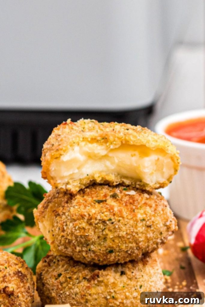Crispy Air Fried Babybel 8 Golden fried cheese rounds stacked in front of an air fryer and sauce.