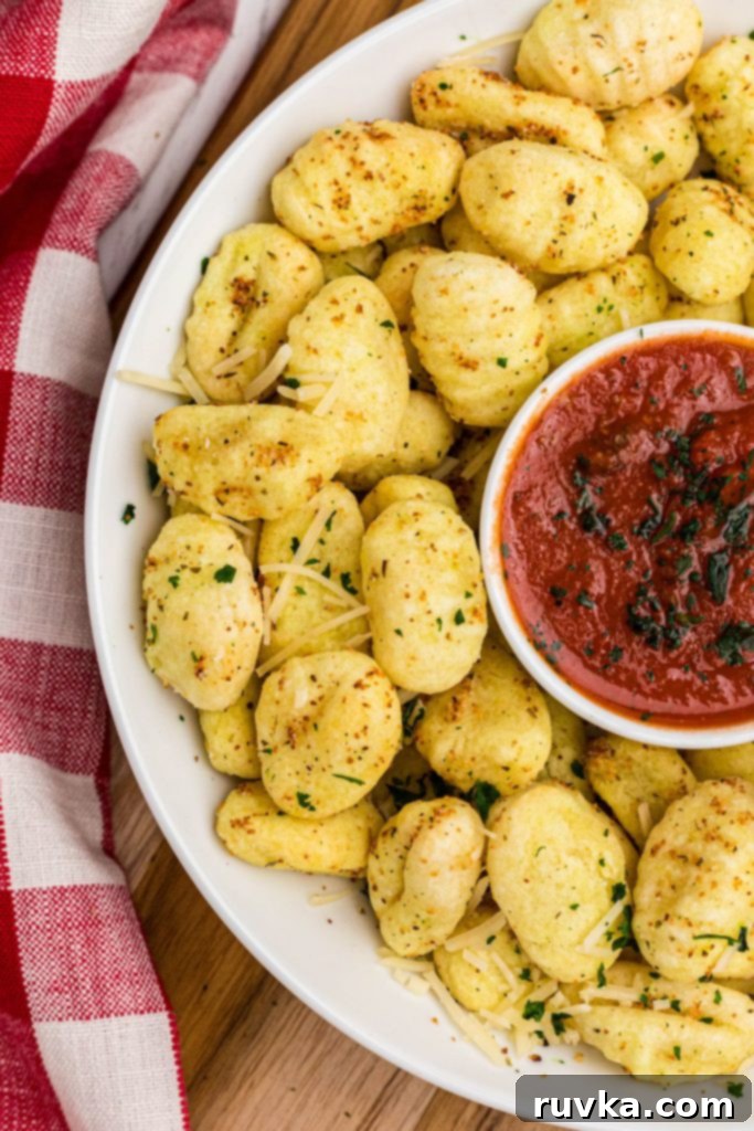 Crispy Air-Fried Gnocchi 8 Golden crispy gnocchi in a white bowl, ready to be served with marinara sauce for dipping.