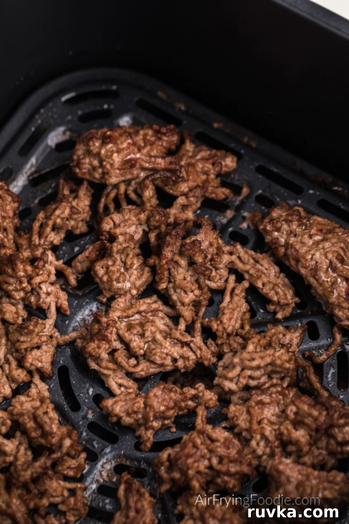 Easy Air Fryer Ground Beef 7 Close up photo of ground beef in the basket of the air fryer.