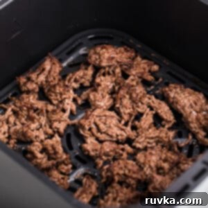Easy Air Fryer Ground Beef 9 Crumbled ground beef in the basket of the air fryer, ready to serve.