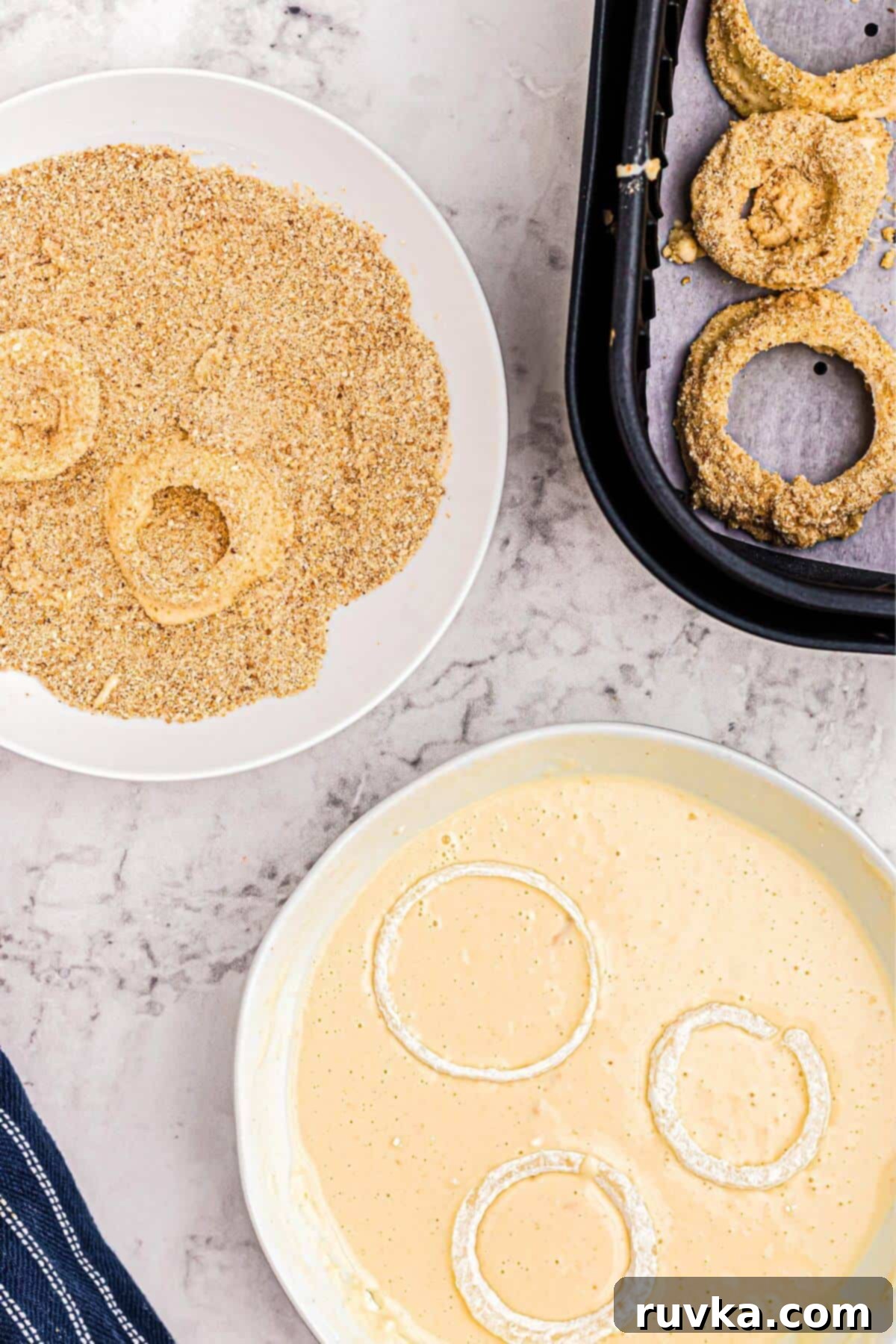 Guilt-Free Air-Fried Onion Rings 6 Flour coated onion slices being dipped into a batter, and then into a bread crumb coating, before being placed in the air fryer basket.