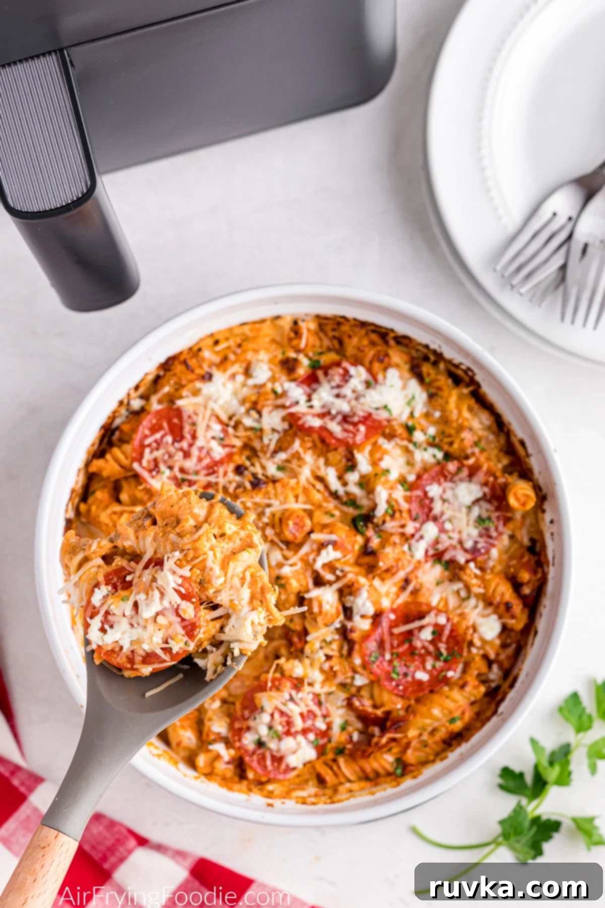 Air Fryer Pizza Pasta Bake 2 Pizza pasta casserole made in the air fryer being scooped from a serving dish.