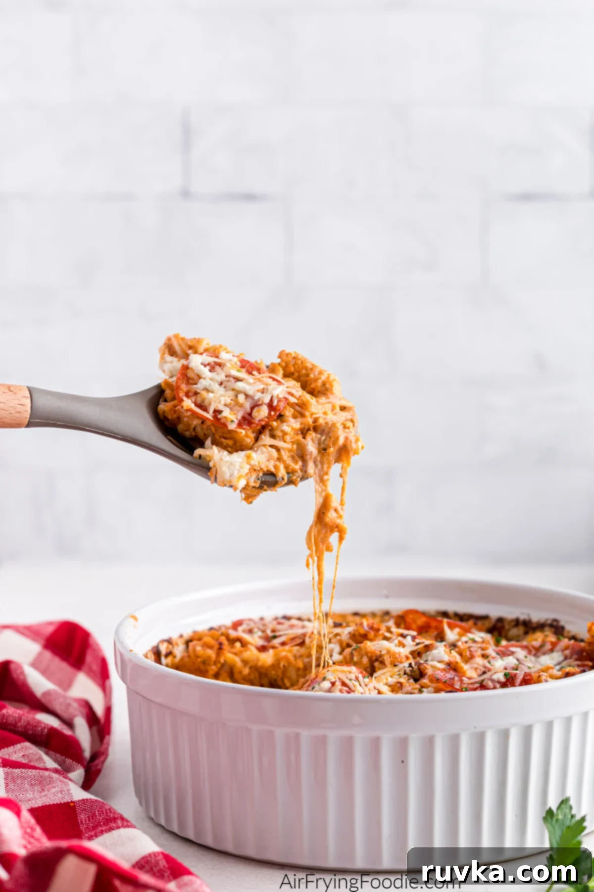 Air Fryer Pizza Pasta Bake 9 Air fryer pizza pasta being scooped from the baking dish.