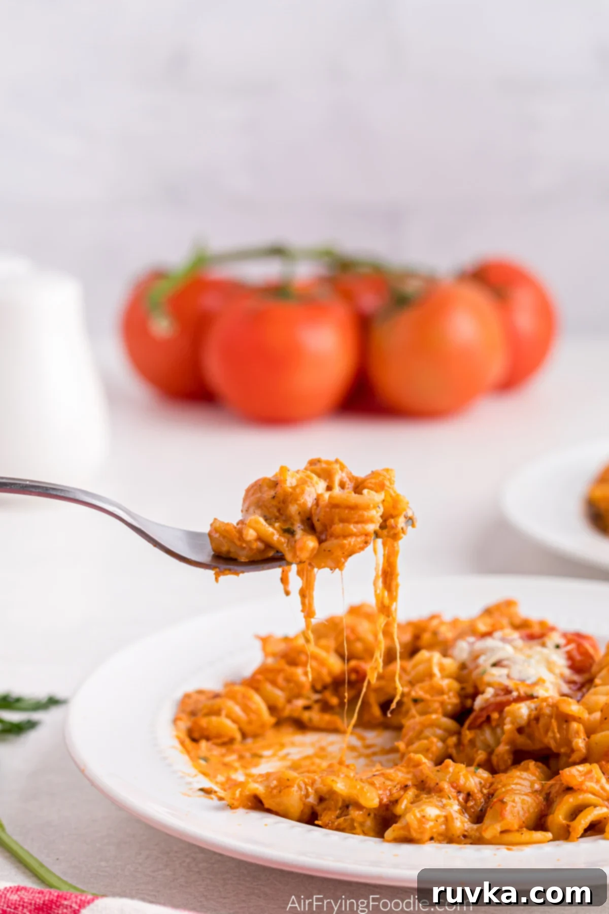 Air Fryer Pizza Pasta Bake 10 Bite of pizza pasta being scooped from a bowl