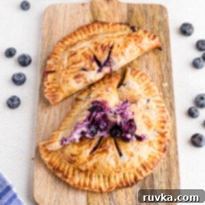 Crispy Air Fried Blueberry Pockets 16 Blueberry hand pies on a cutting board, ready to eat.