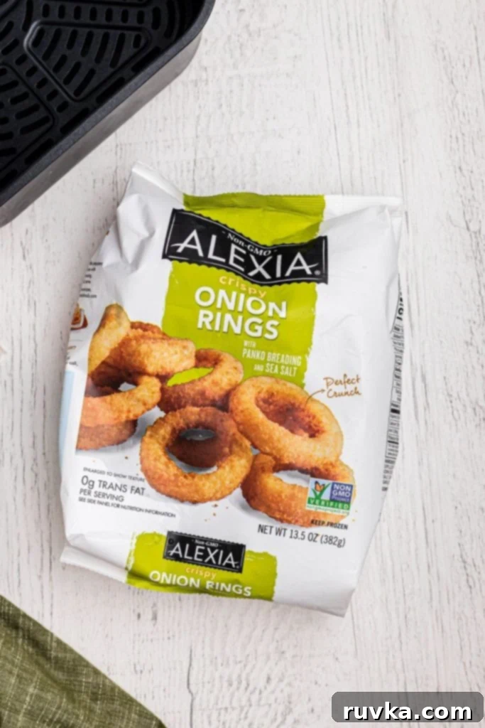 Effortlessly Crispy Air Fryer Onion Rings 3 One bag of alexia crispy onion rings on a white wooden table with an air fryer basket.