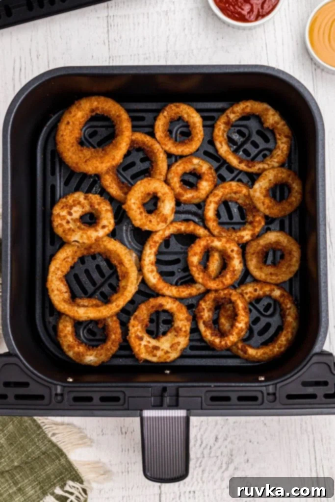 Effortlessly Crispy Air Fryer Onion Rings 5 Golden crispy cooked onion rings in the air fryer basket.