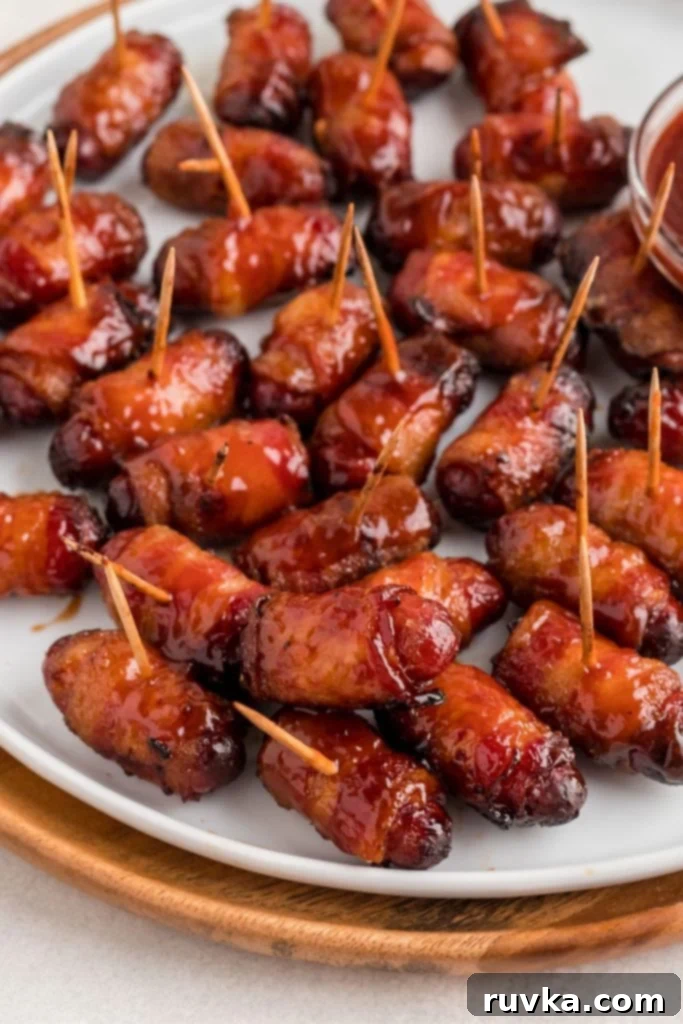 Crispy Air-Fried Bacon-Wrapped Smokies 8 Juicy BBQ coated bacon wrapped smokies on a white plate.