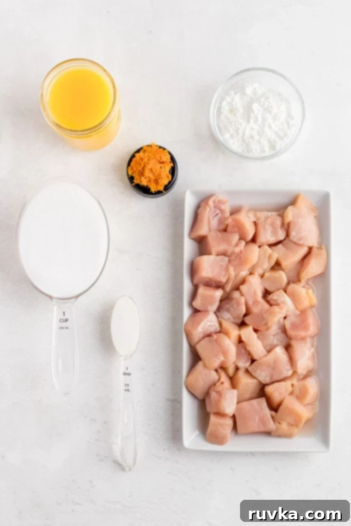 Golden Crispy Air Fryer Orange Chicken 3 Ingredients needed to make orange chicken on a white marble table.