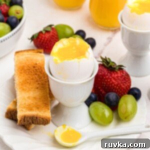 Air Fryer Jammy Eggs 8 Slightly runny yolk inside of an egg shell in an egg holder with fruit and toast.